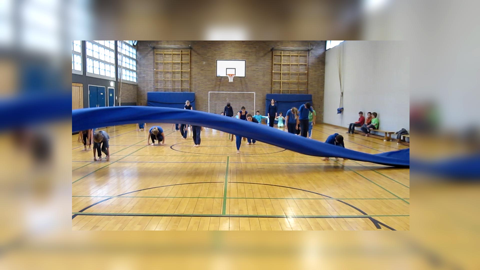 Schülerinnen und Schüler üben ein Stück mit Requisite in der Turnhalle einer öffentlichen Schule in Düsseldorf